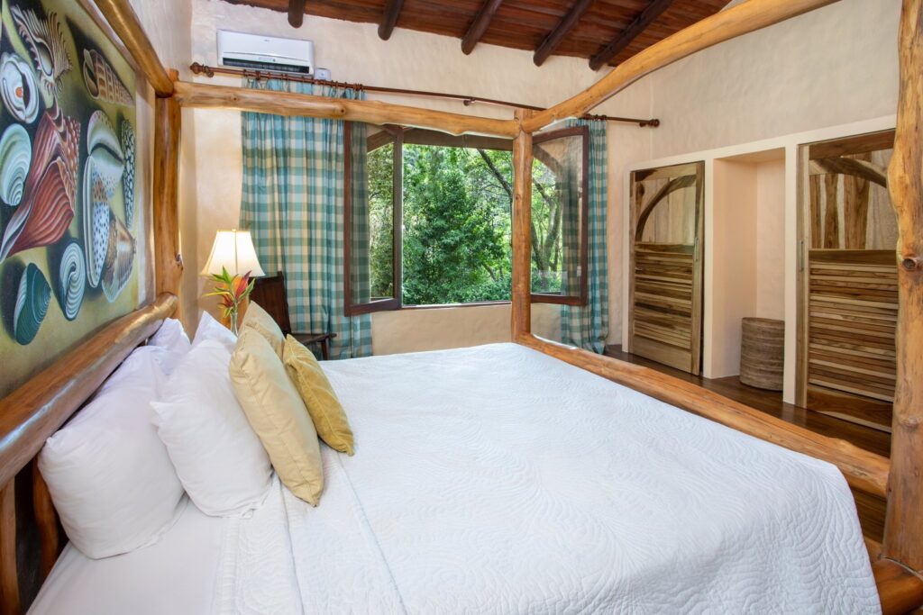 This huge air-conditioned bedroom has large windows that look out over the jungle.