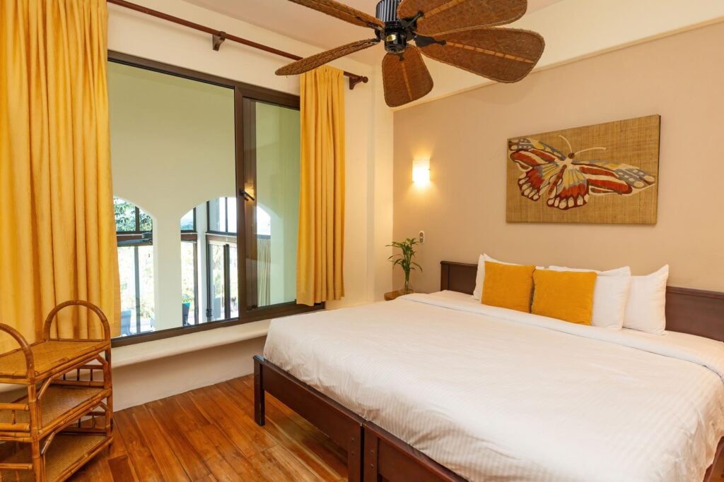 A cozy bedroom filled with warm tones and natural light, creating a comfortable space to rest and recharge.