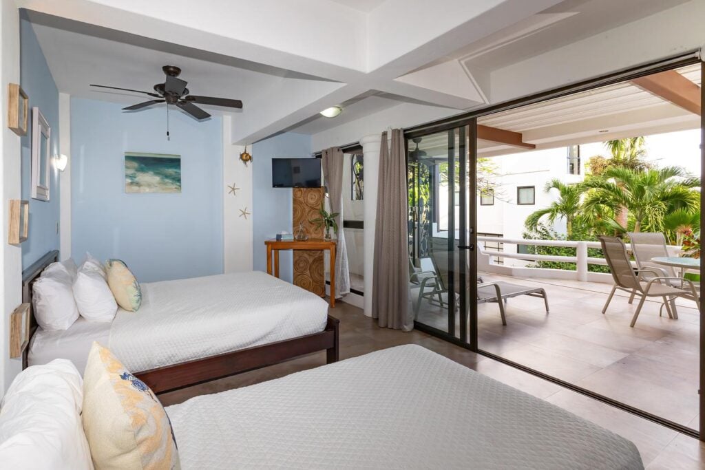 A bright twin bedroom with direct access to a private terrace, offering a comfortable indoor space with easy outdoor enjoyment.