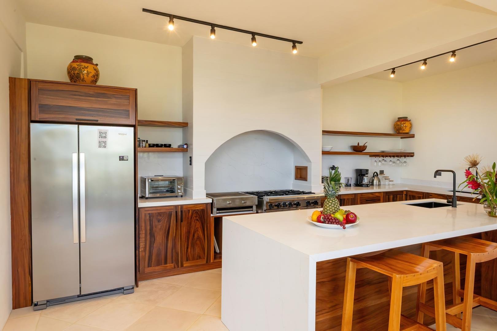Modern kitchen with custom wood cabinets, island seating, and stainless steel appliances