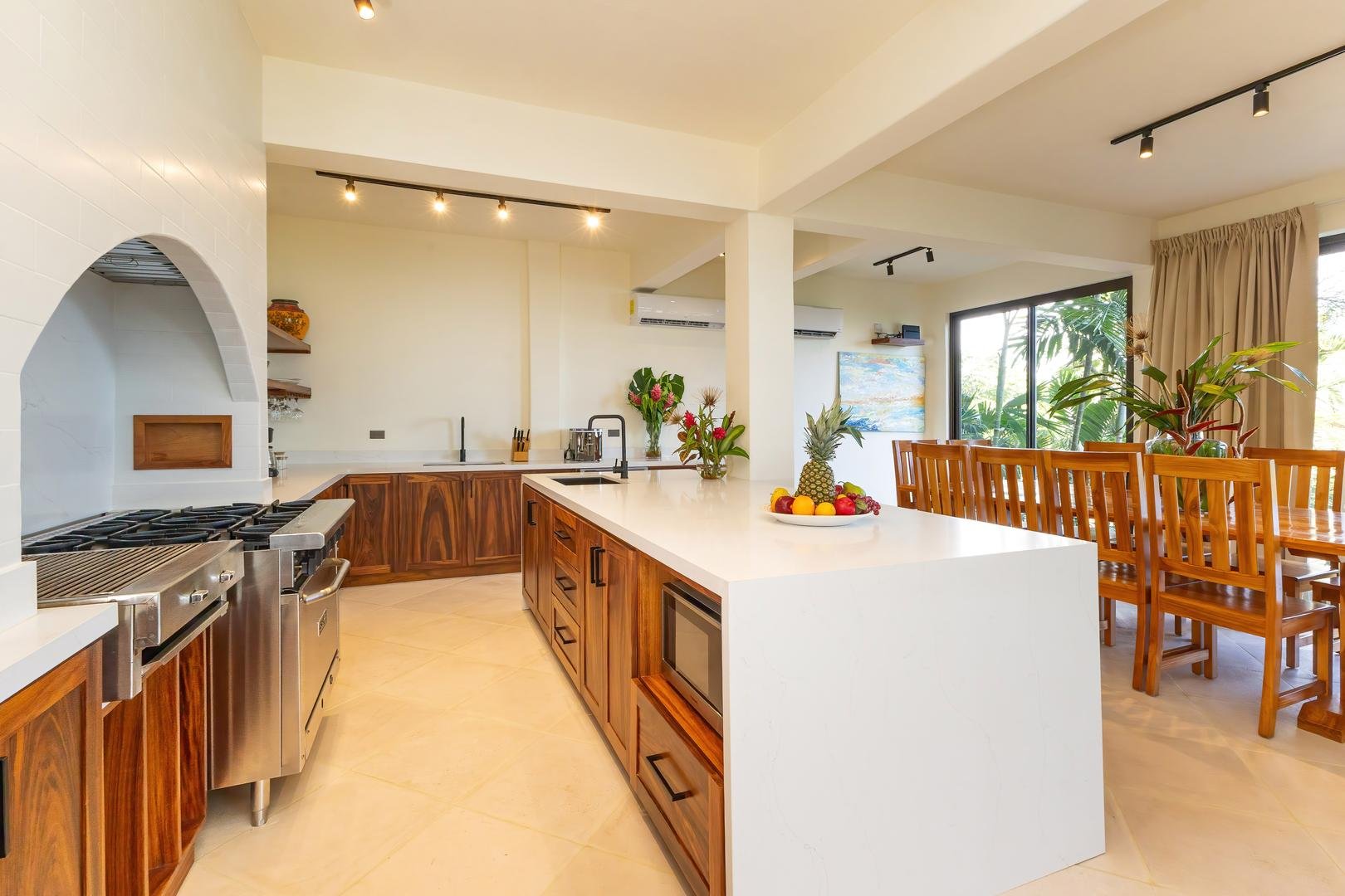 Open-concept kitchen with large island and dining table in a Manuel Antonio villa
