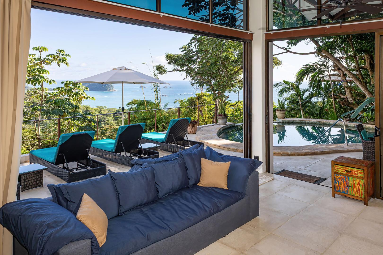 Open living space leading to a pool terrace with ocean views and tropical greenery in Manuel Antonio
