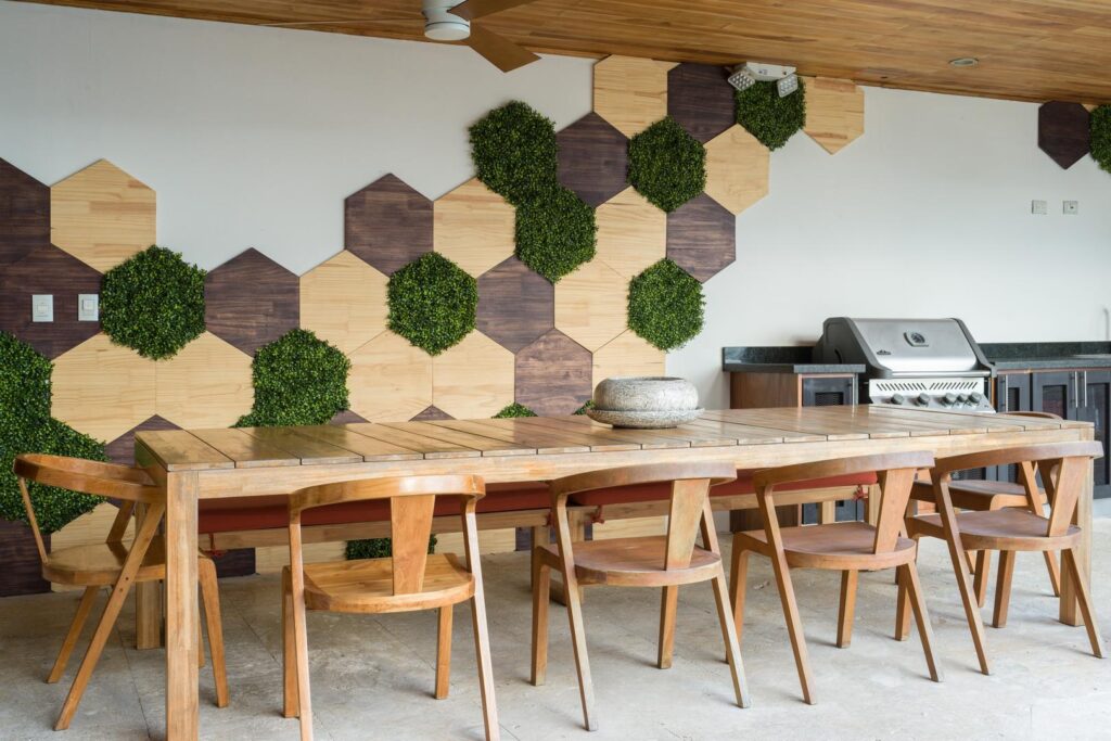 A modern outdoor dining area with natural wood textures, geometric green accents, and a built-in grill—perfect for relaxed meals al fresco.