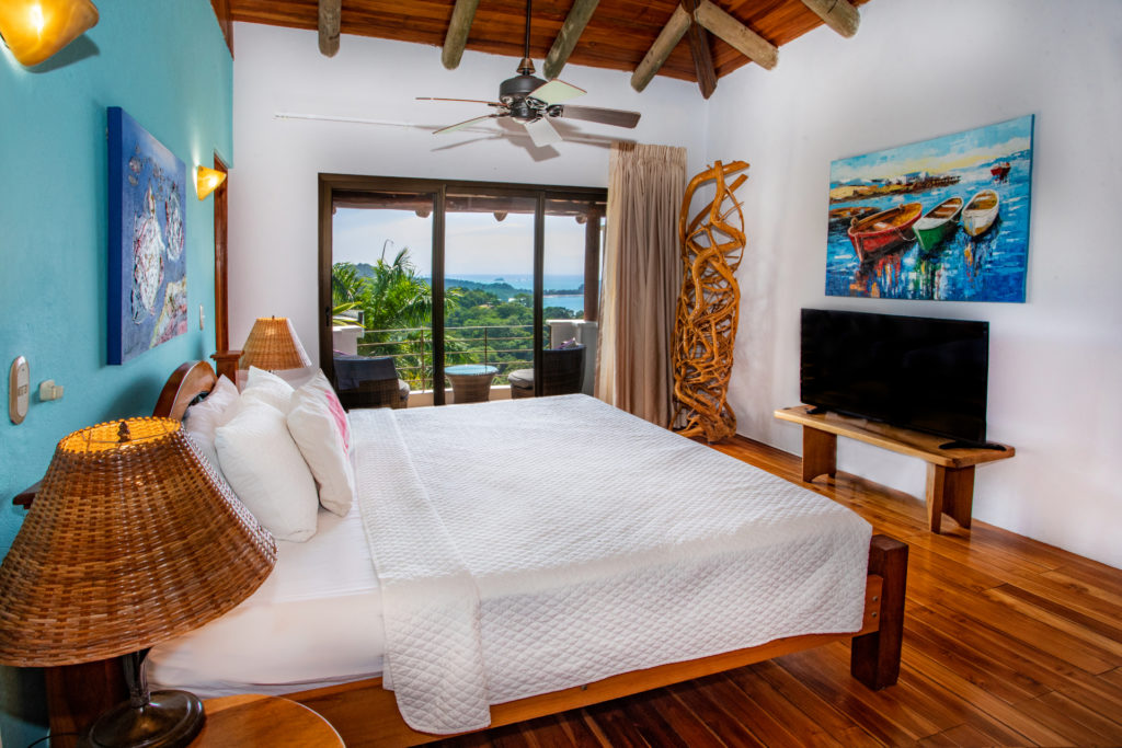 A king and double bed, TV, and private balcony are featured in this large bedroom.
