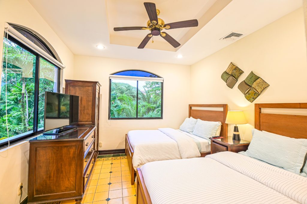 This cozy bedroom features two queen size beds and jungle view.