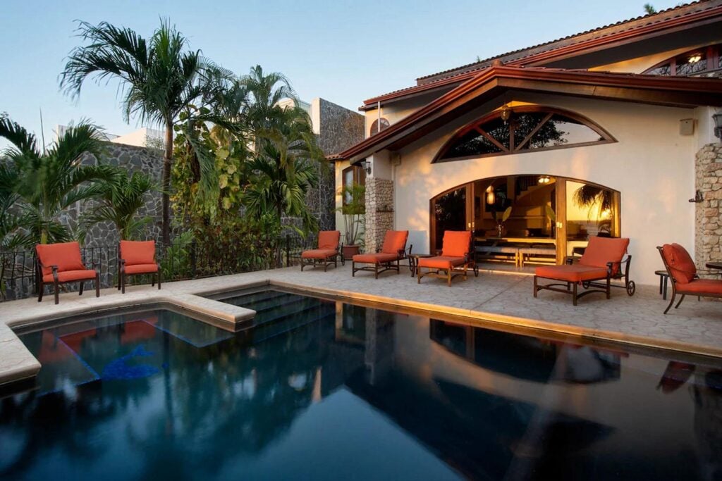 In the early evening, the pool area takes on an enchanting vibe as the sunset brings out vibrant colors in the sky.