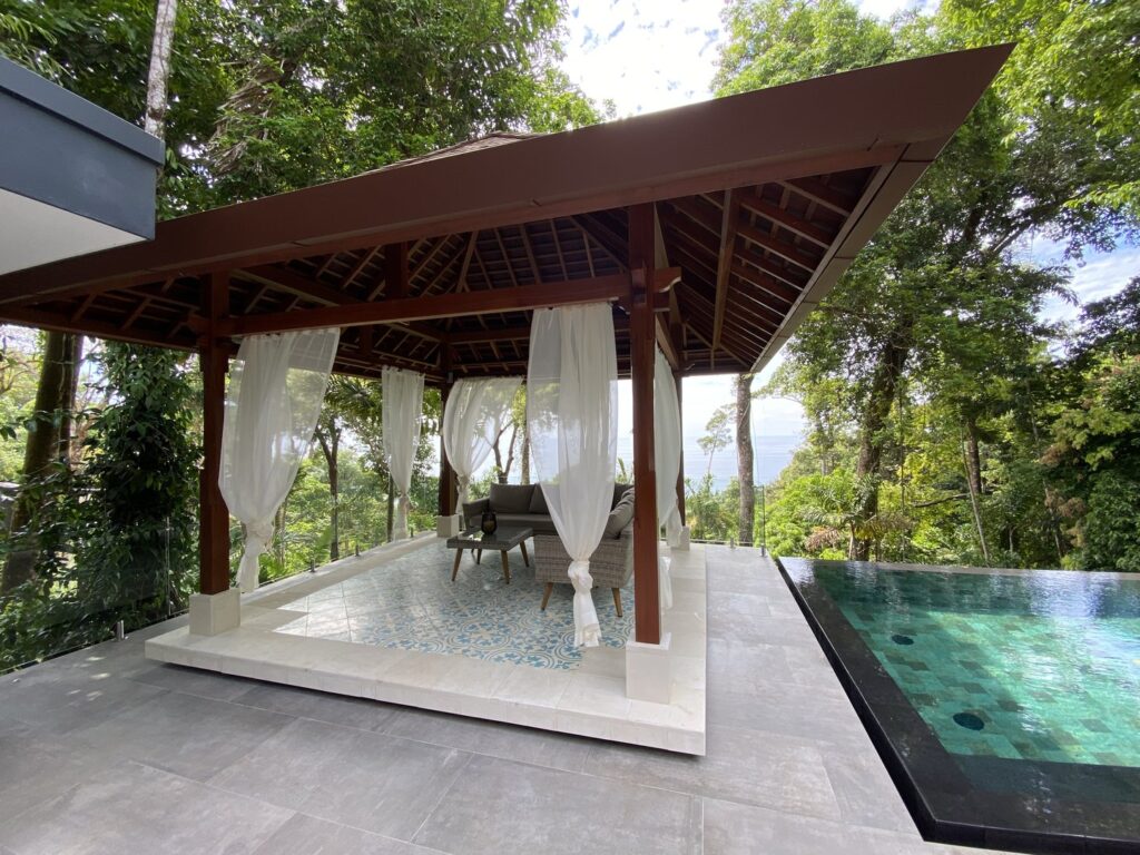 A luxury covered seating area is next to the infinity pool.