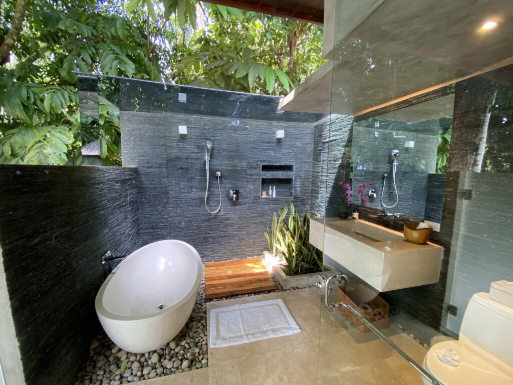 The beautiful master ensuite bathroom is outside under the rainforest canopy.