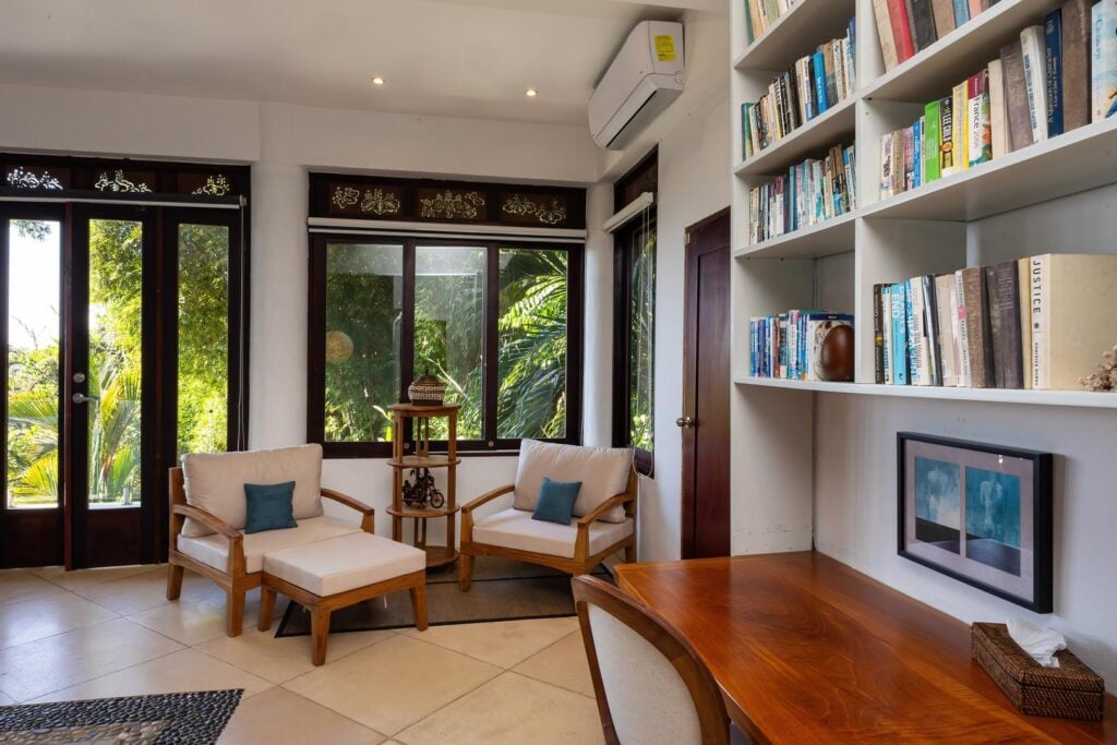 Quiet air-conditioned reading nook with built-in shelving and jungle views.