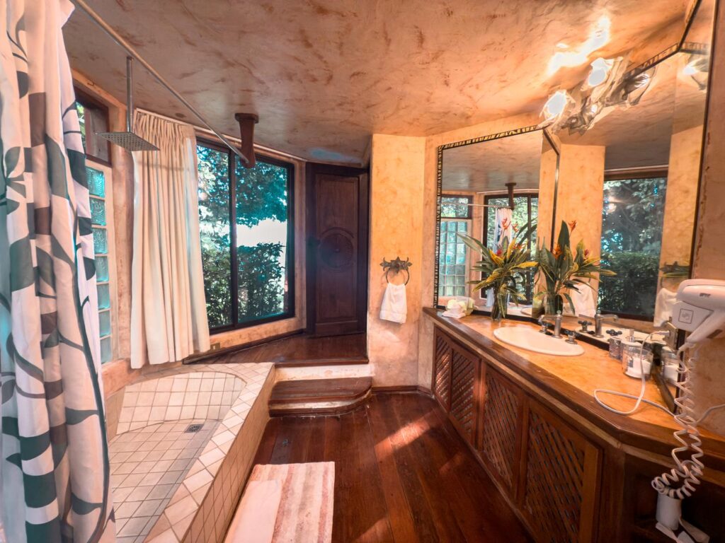 Serene bathtub retreat, bathed in natural light and framed by lush, exotic gardens.