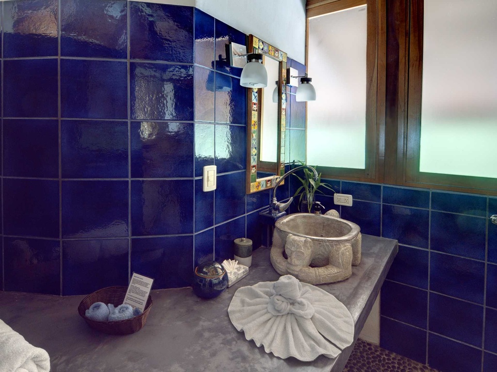 This beautifully-designed bathroom on the top level features ocean blue tiles and unique fixtures.