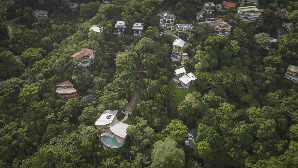 The villa is located on a hillside in a secure gated community embraced by the rainforest. 