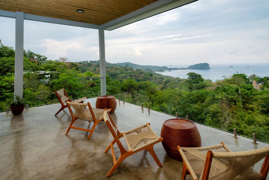 Seats with coffee tables on the luxury terrace enjoying a stunning view of the rainforest and coastline.