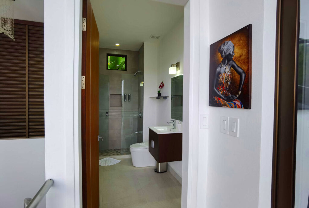 This amazing home is decorated with beautiful art throughout like this piece outside the shared bathroom.