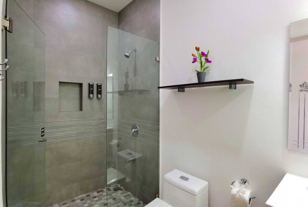 This tastefully-designed bathroom has a beautiful tiled glass-door shower.