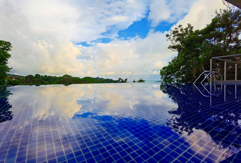 Your stunning infinity pool reflects the clear sky and blends in with its natural surroundings.