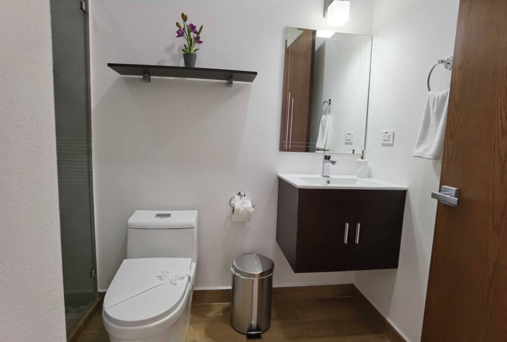 This modern bathroom is newly furnished and tastefully decorated with wooden features.