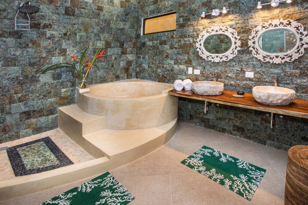 The amazing master bathroom has a luxurious soaking tub, shower, and his and hers natural stone sinks. 
