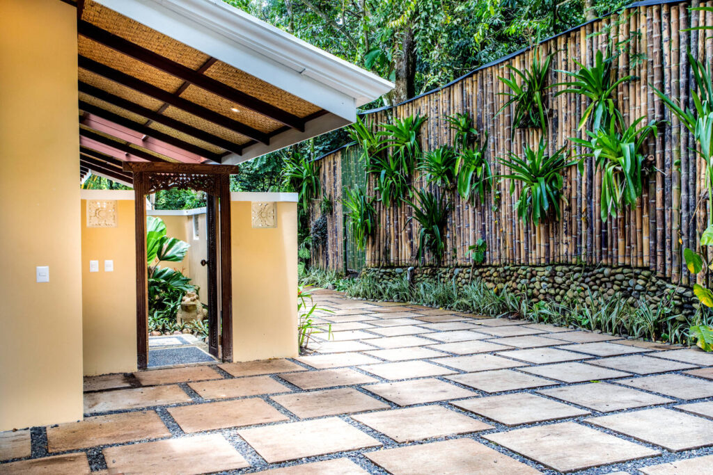 The tall bamboo privacy fence protects the parking area and front entrance of the property. 
