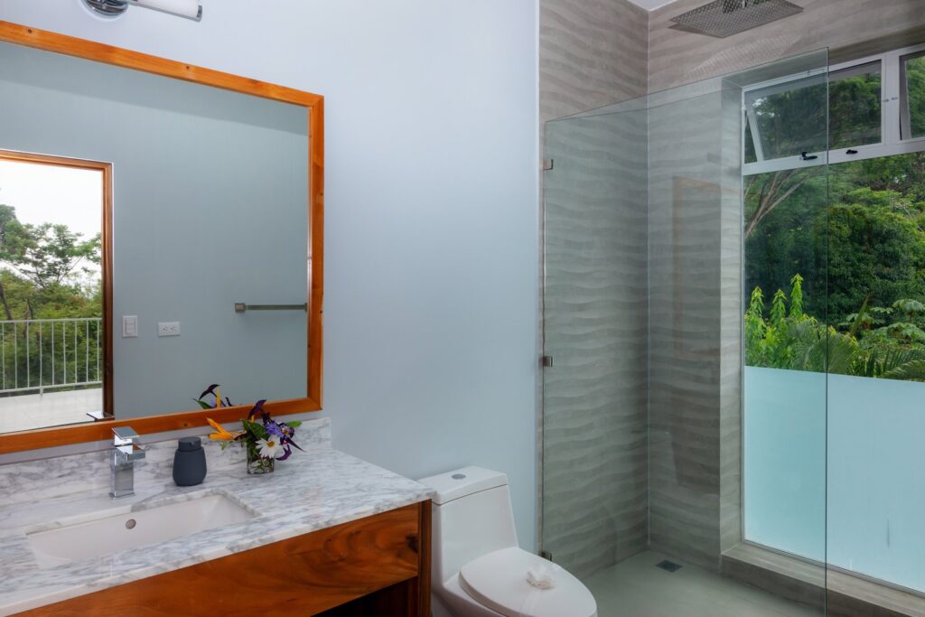 Enjoy your gorgeous rainforest view as you take a refreshing rain shower in this luxury bathroom.