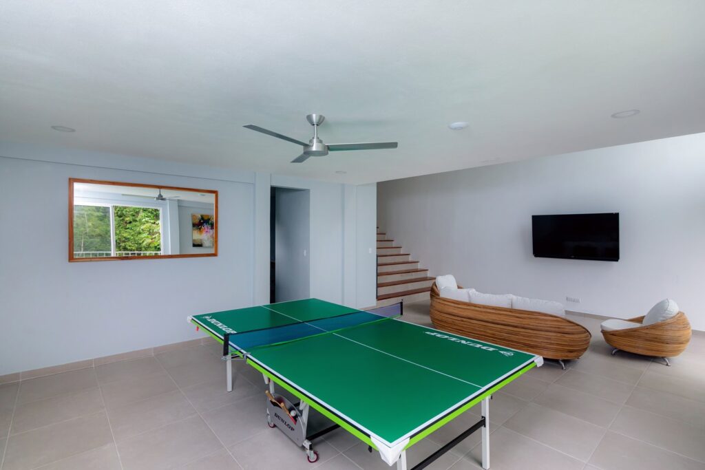 This large living room has a modern entertainment system and a ping pong table.