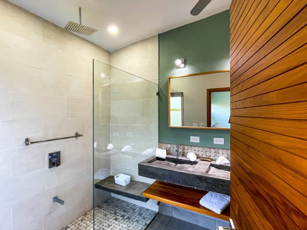Bathrooms with beautiful wooden features and natural tiles.
