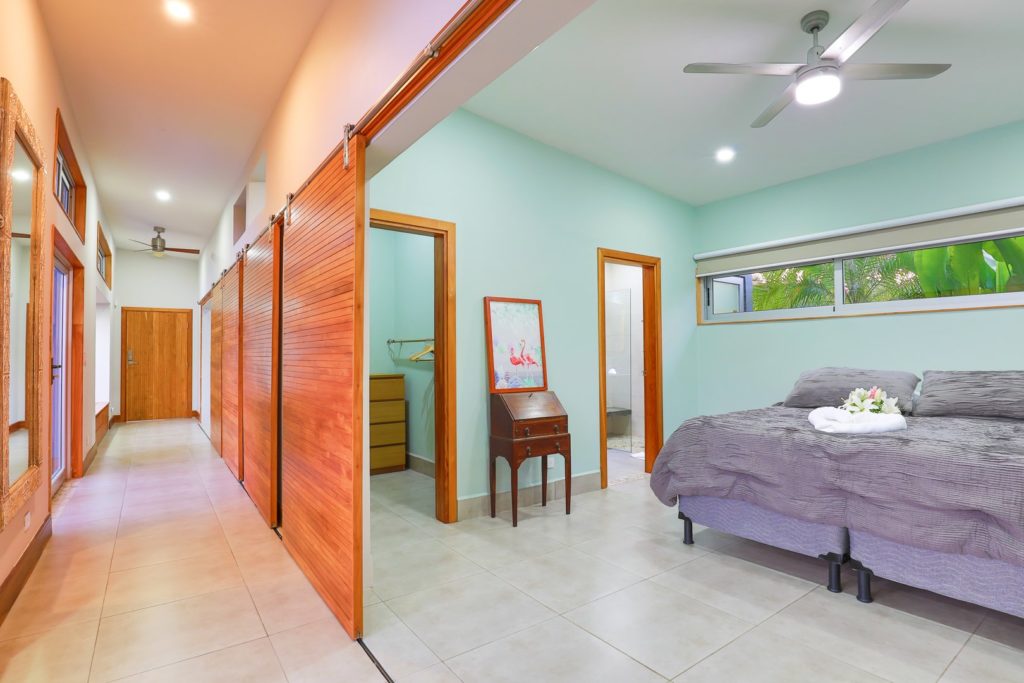 Some of the bedrooms have large sliding doors opening towards the pool area.