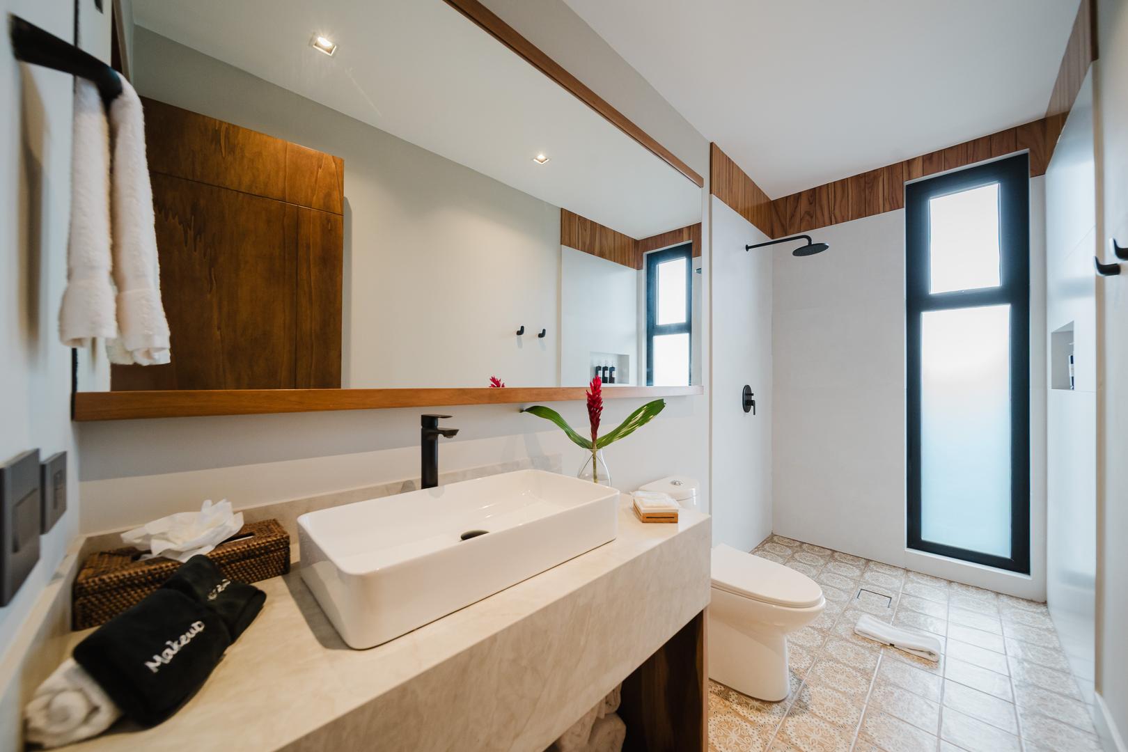 Modern bathroom with vessel sink walk-in shower and natural light in Manuel Antonio Costa Rica