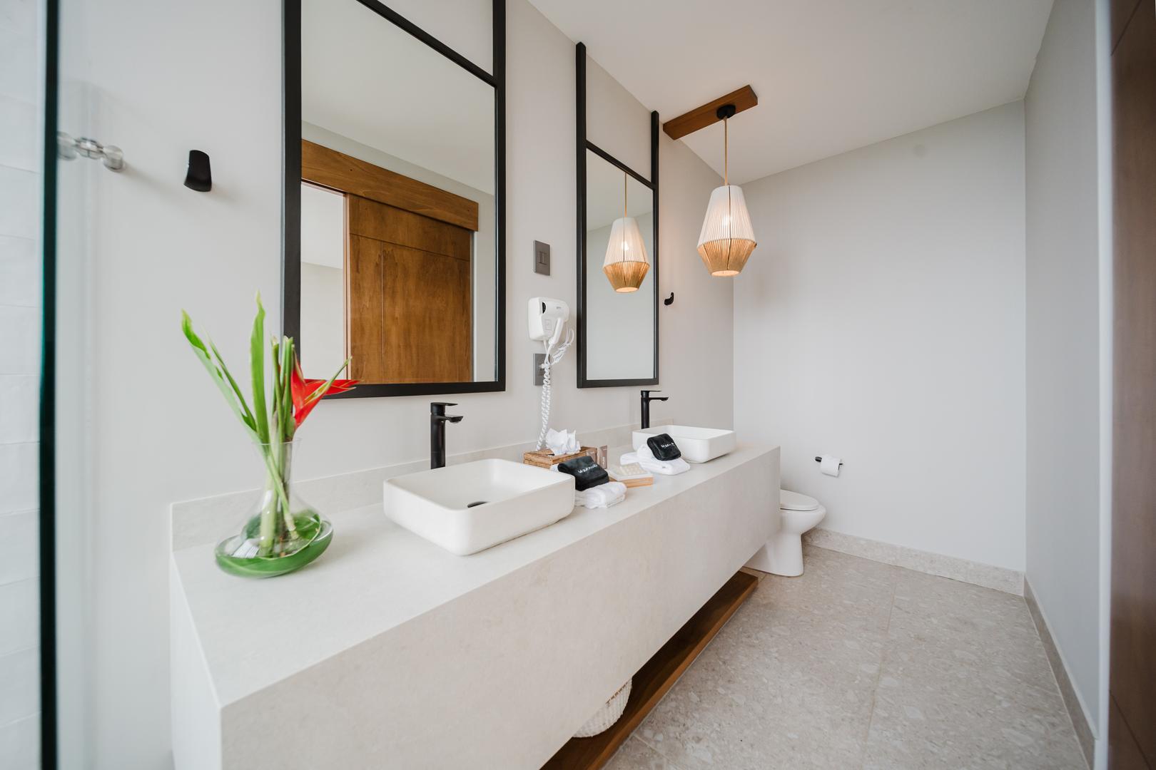 Bathroom with double vanity sinks, mirrors, and modern lighting in Manuel Antonio Costa Rica