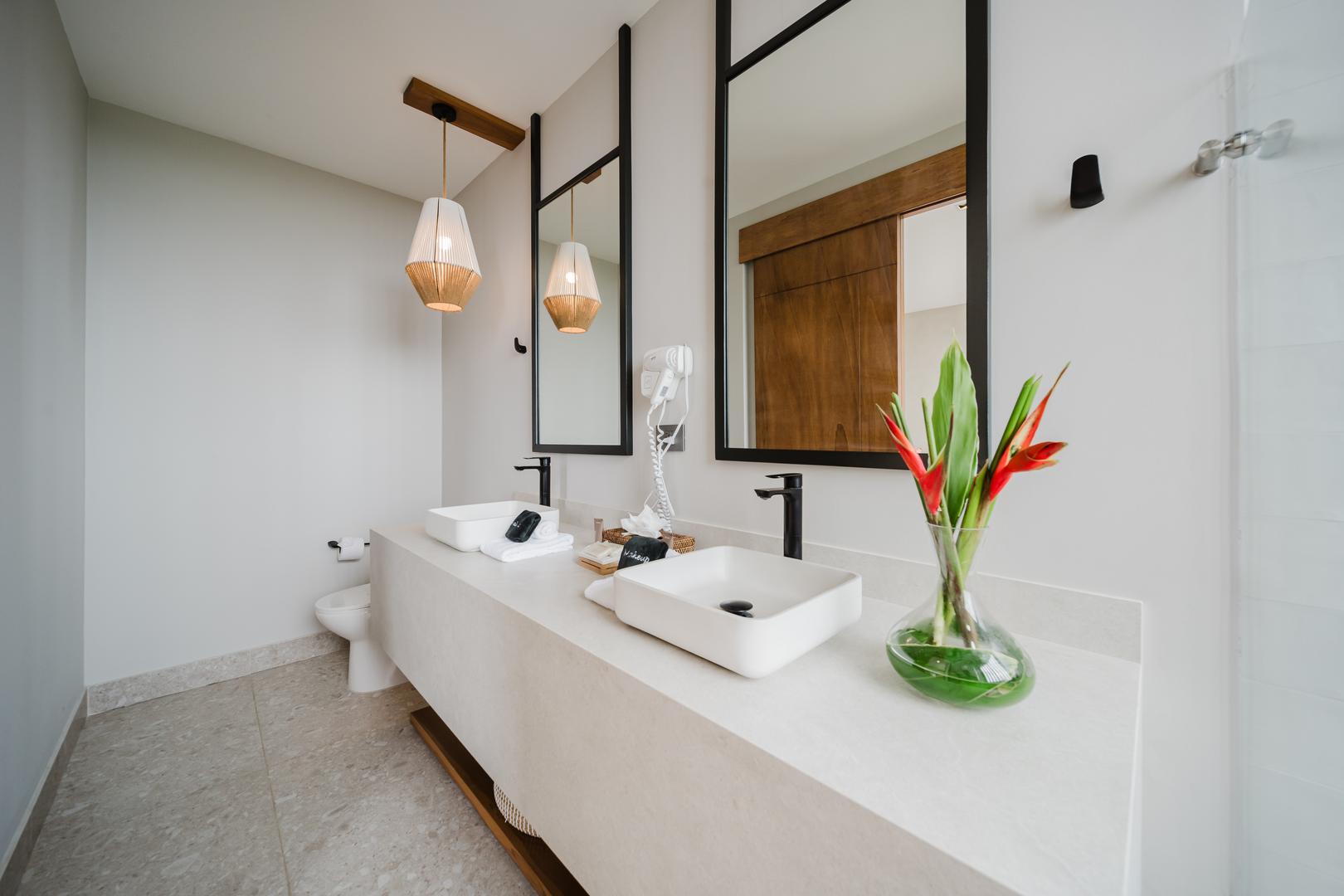 Modern bathroom with double vanity sinks mirrors pendant lights in Manuel Antonio Costa Rica