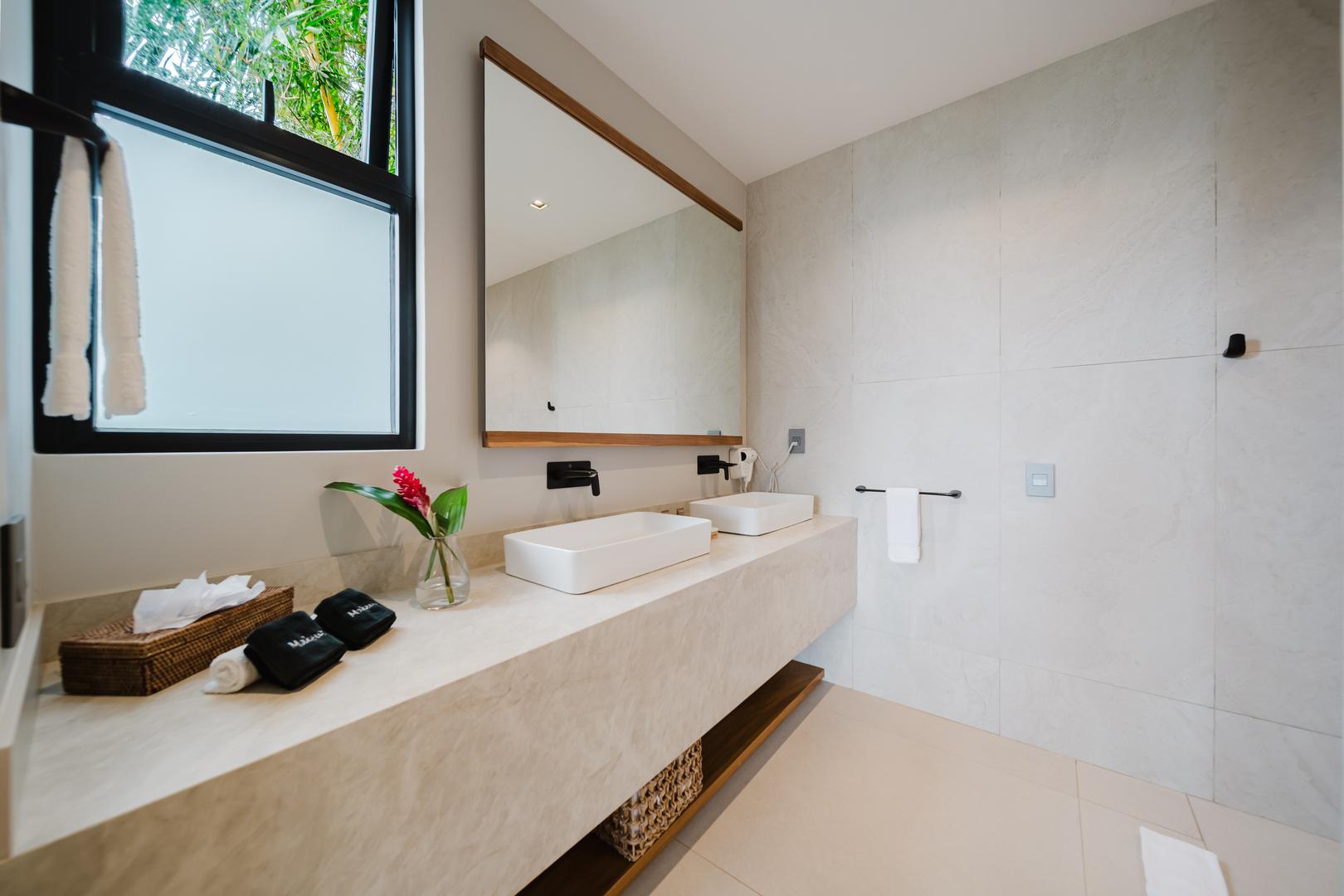 Modern bathroom with double vanity sinks and large mirror in Manuel Antonio Costa Rica