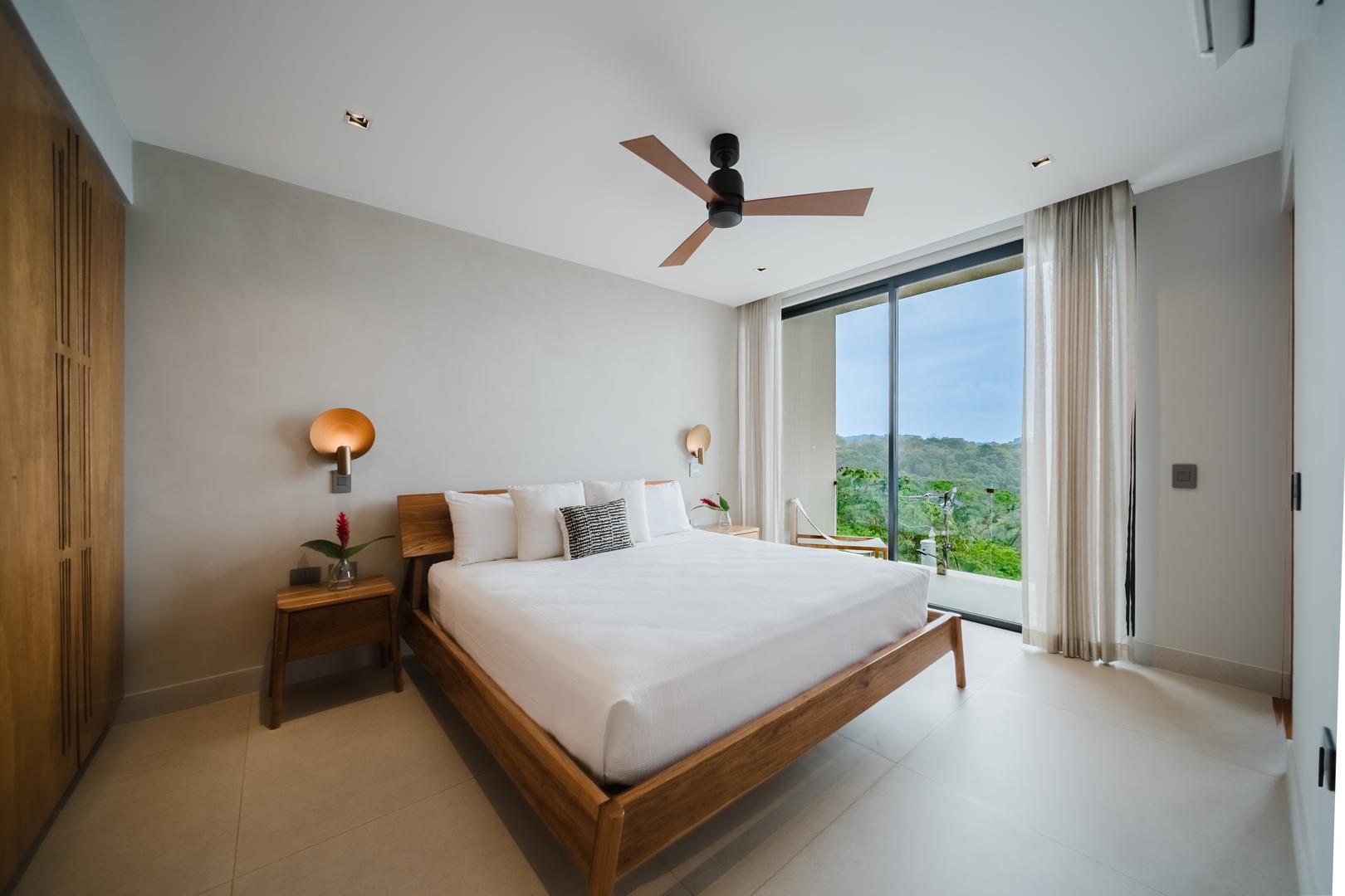Modern bedroom with jungle and ocean views and sliding glass doors in Manuel Antonio Costa Rica