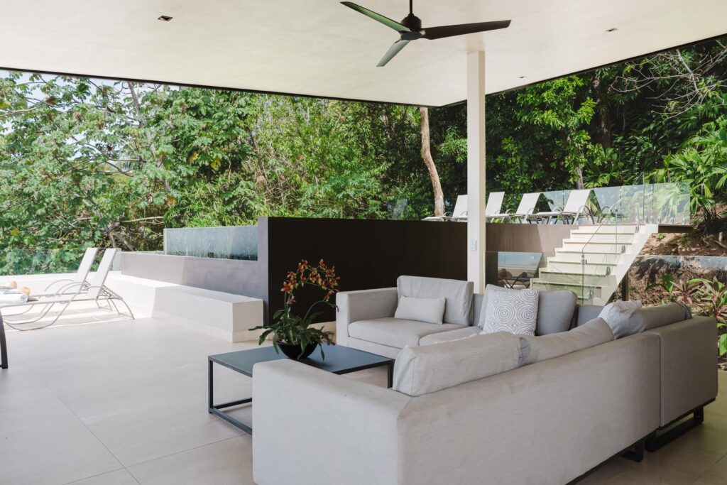 A relaxed open-air lounge space beside the pool, surrounded by nature.