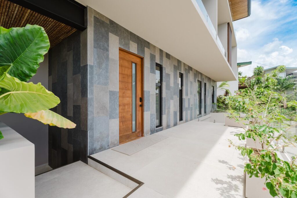 A contemporary villa entrance framed by clean lines and tropical greenery.