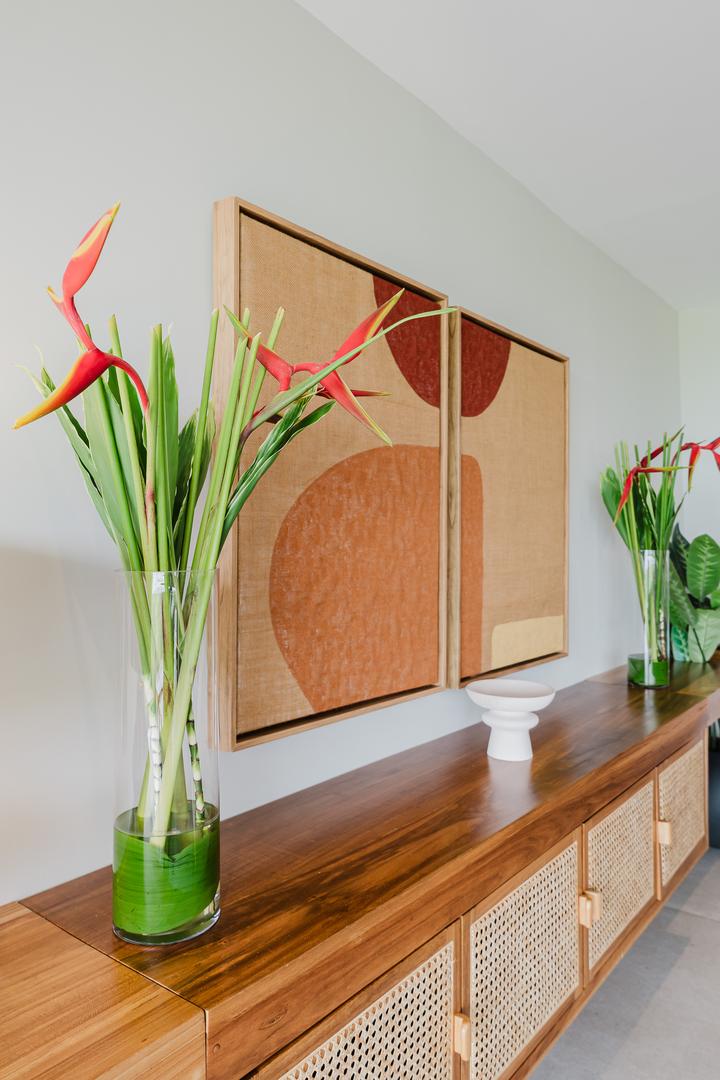 Interior decor with wooden console table, artwork, and tropical flowers in Manuel Antonio Costa Rica