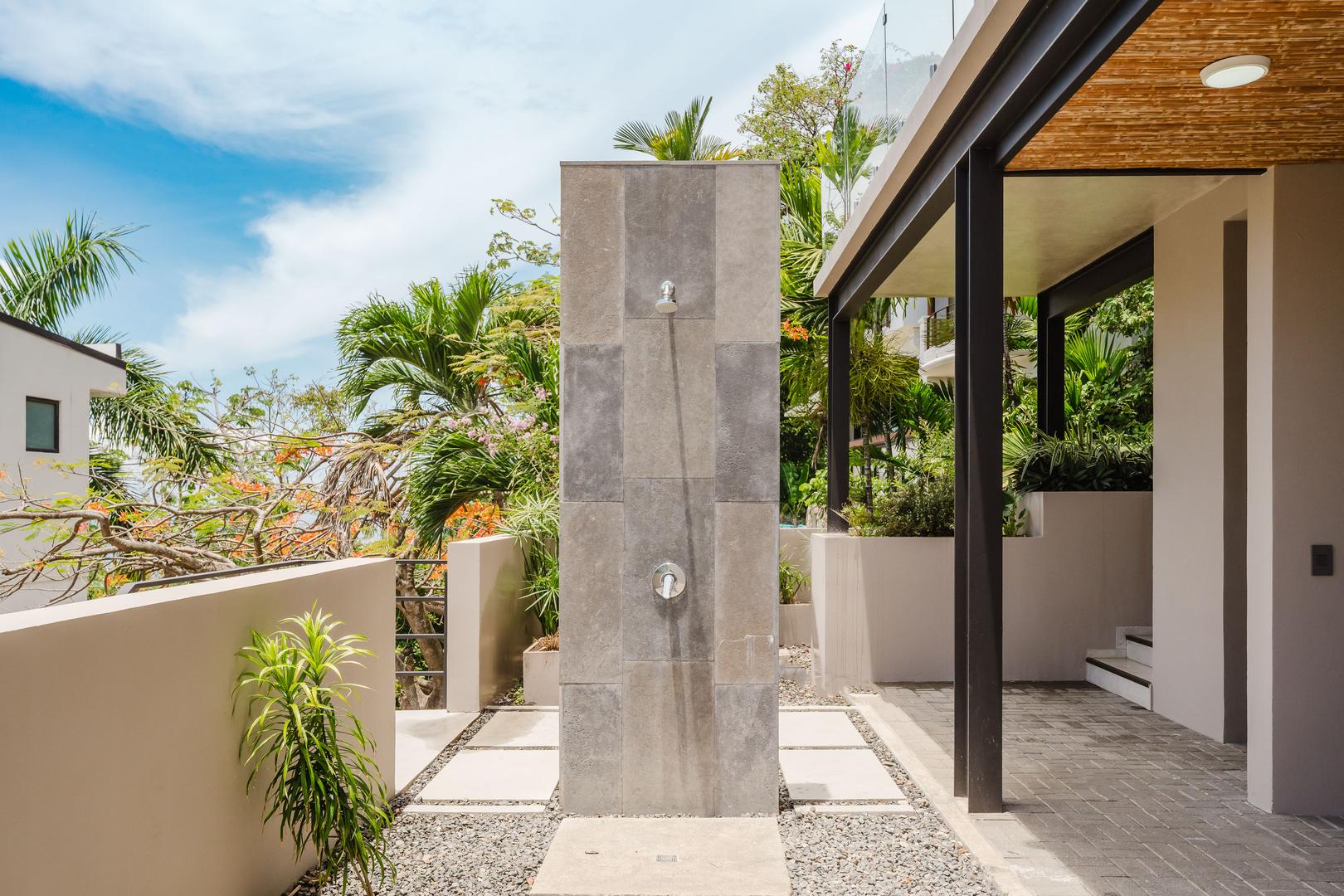Outdoor shower with stone wall and tropical plants at luxury villa Manuel Antonio Costa Rica