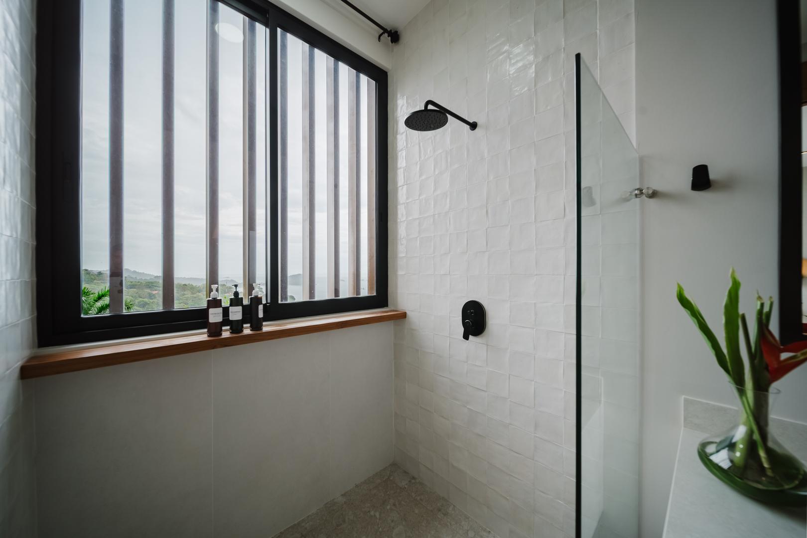 Modern shower with window view and black fixtures in Manuel Antonio Costa Rica