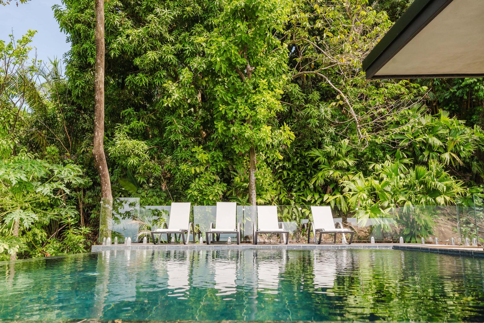 Infinity pool with lounge chairs surrounded by tropical jungle in Manuel Antonio Costa Rica