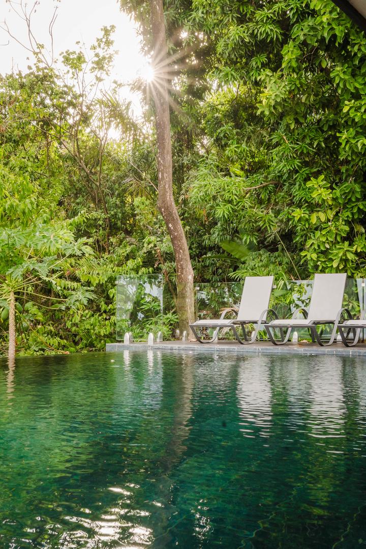 Infinity pool with sun loungers surrounded by tropical jungle in Manuel Antonio Costa Rica