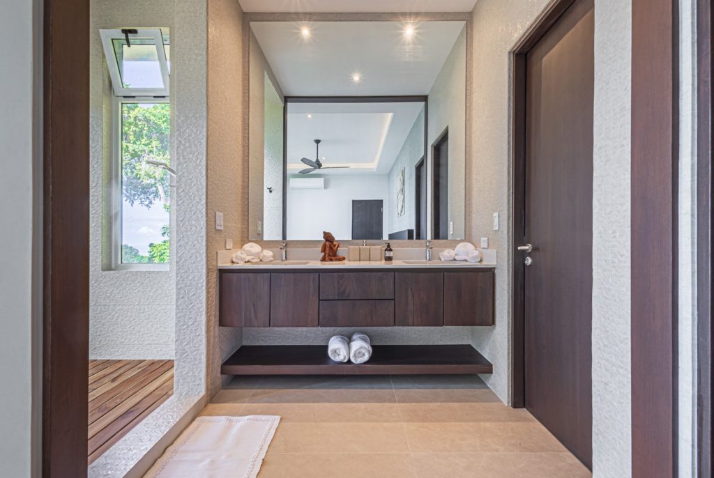 This gorgeous ensuite bathroom has a simple design using high-quality decor and furnishings.