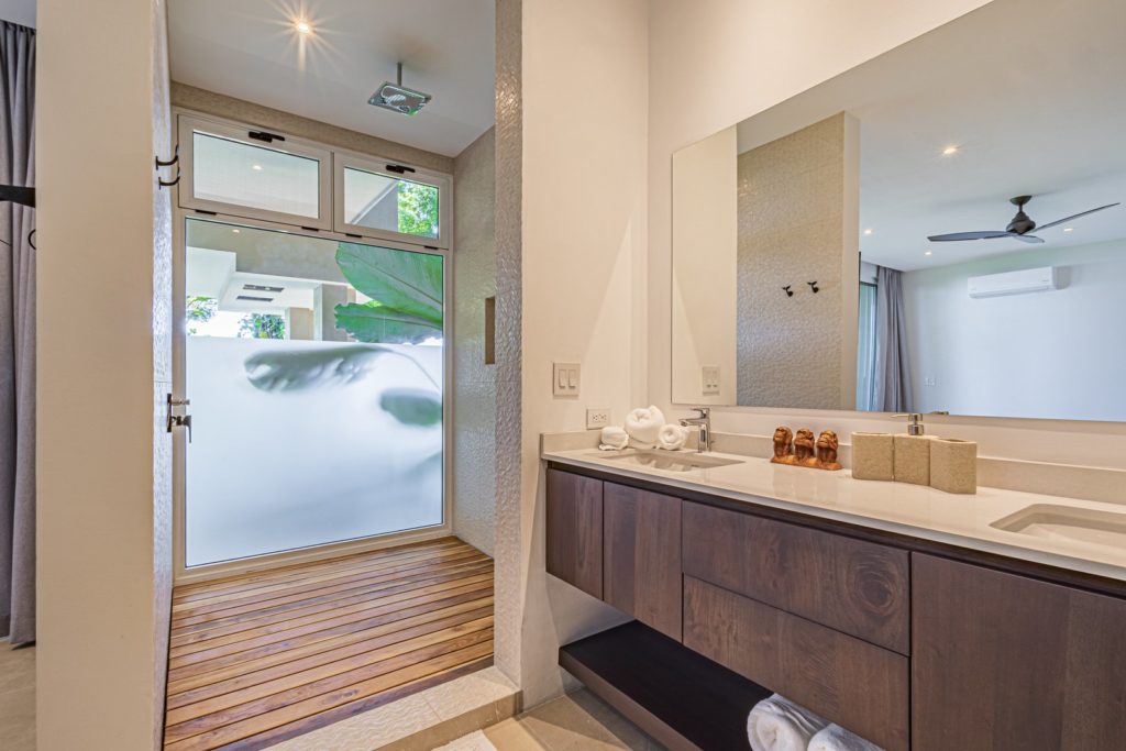 This luxury bathroom has a wooden drain deck under the high-quality rain shower. No expense has been spared.