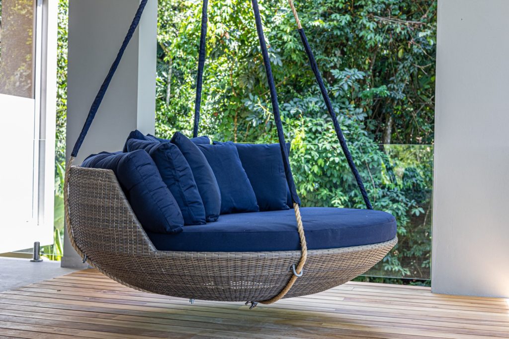 This comfortable hanging day bed is the perfect spot to enjoy a nap or a good book on a lazy afternoon.