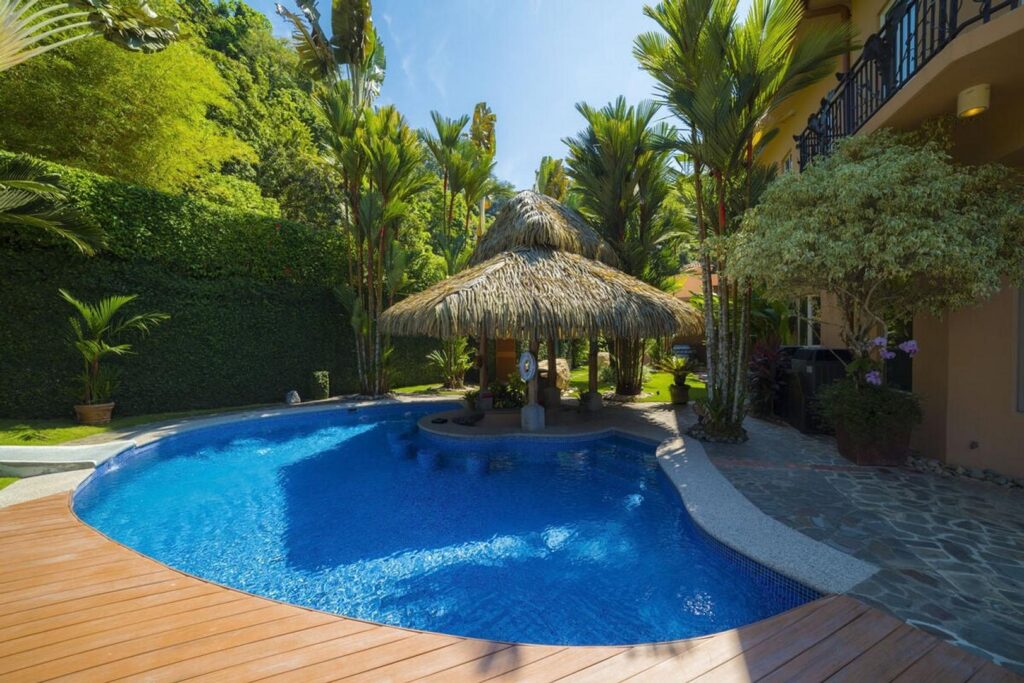 Enjoy a relaxing afternoon in the pool, bordered by a perfectly-maintained garden of lush tropical plants.