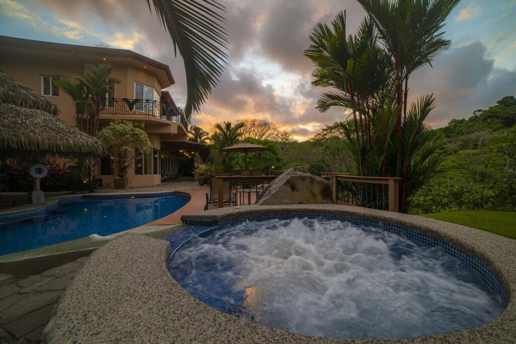 As the sun sets, relax in the jacuzzi hot tub with a drink or two.