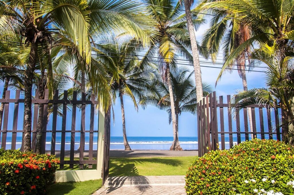 Walk right out the gate, past the palms, and you’re on Jaco’s golden beach — barefoot ready.