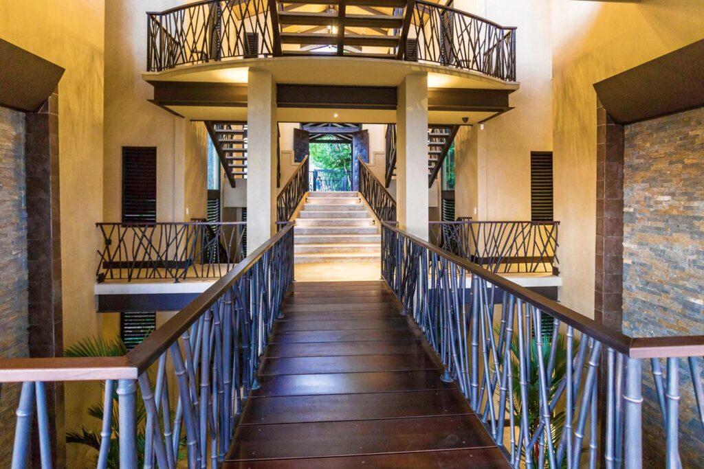 Walk across the villa’s striking bridgeway, framed by tropical light and air.