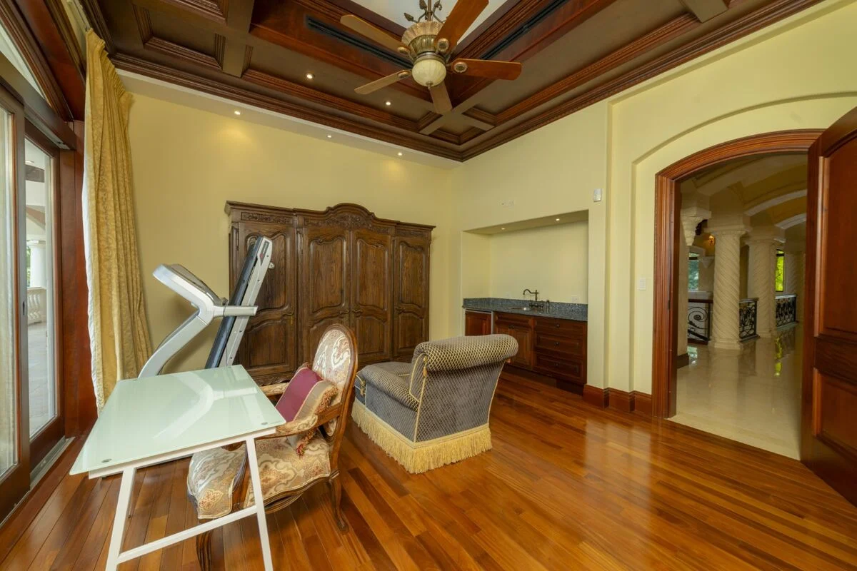 luxury villa bedroom in los suenos with seating area desk wood floors and ceiling fan