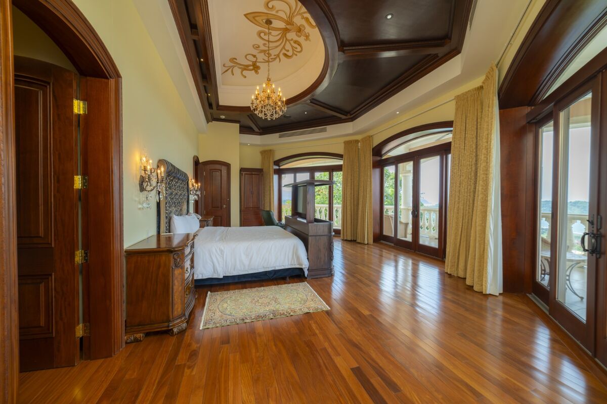 luxury villa master bedroom in los suenos with balcony ocean view wood floors chandelier and large windows
