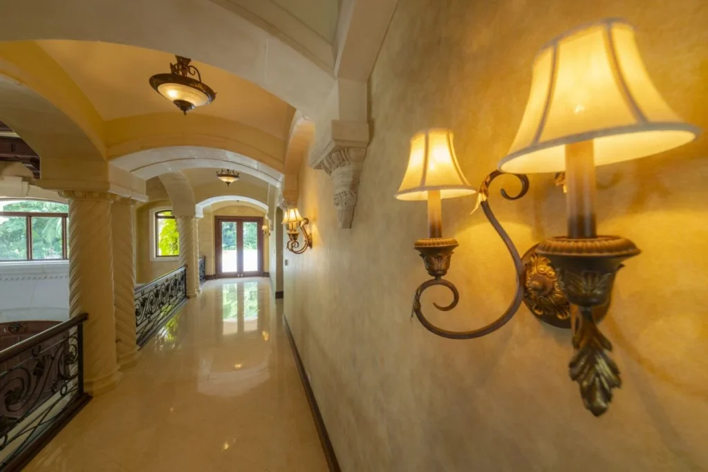 A softly lit hallway with arched details and warm finishes, connecting the home’s private and social spaces.