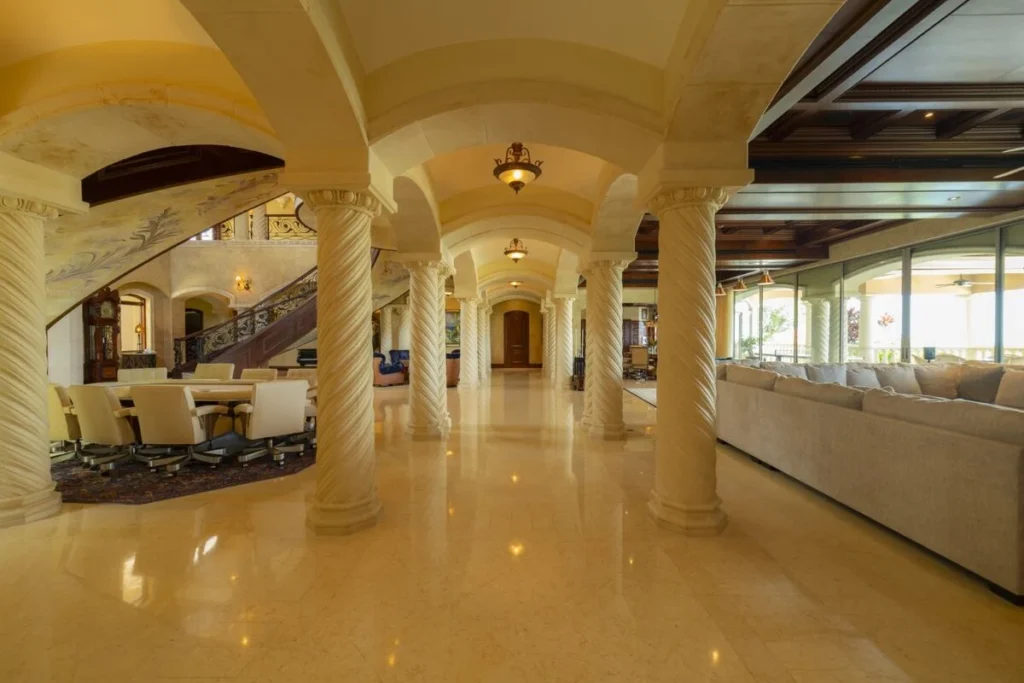 Expansive living and dining areas flow beneath arched ceilings and sculpted columns, designed for gathering and entertaining.